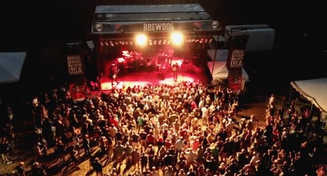 The band, Cold War Kids play outdoors on stage at night at the 2019 BrewDog USA Annual General Meeting.